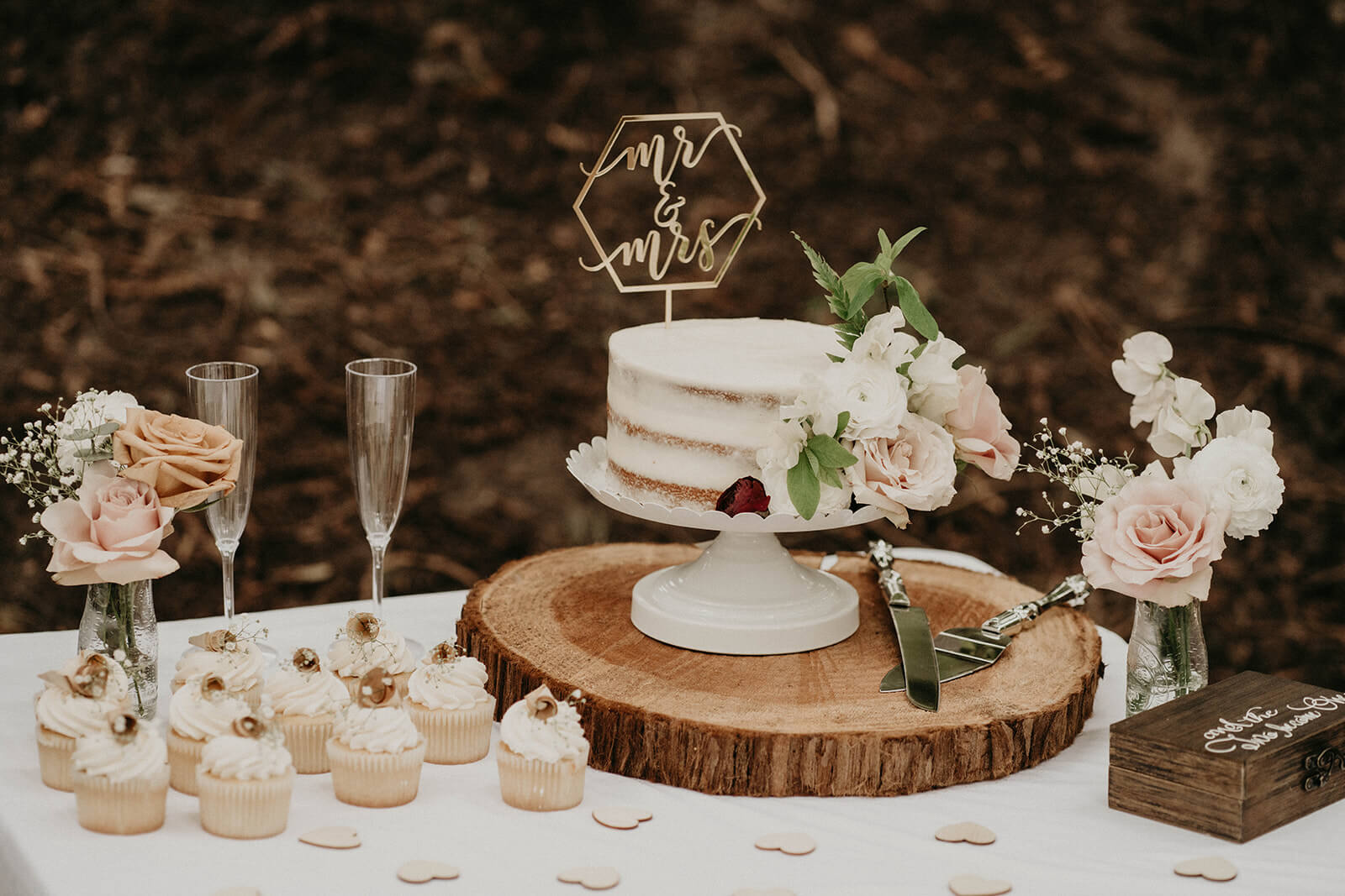 White wedding cake and cupcakes at forest elopement