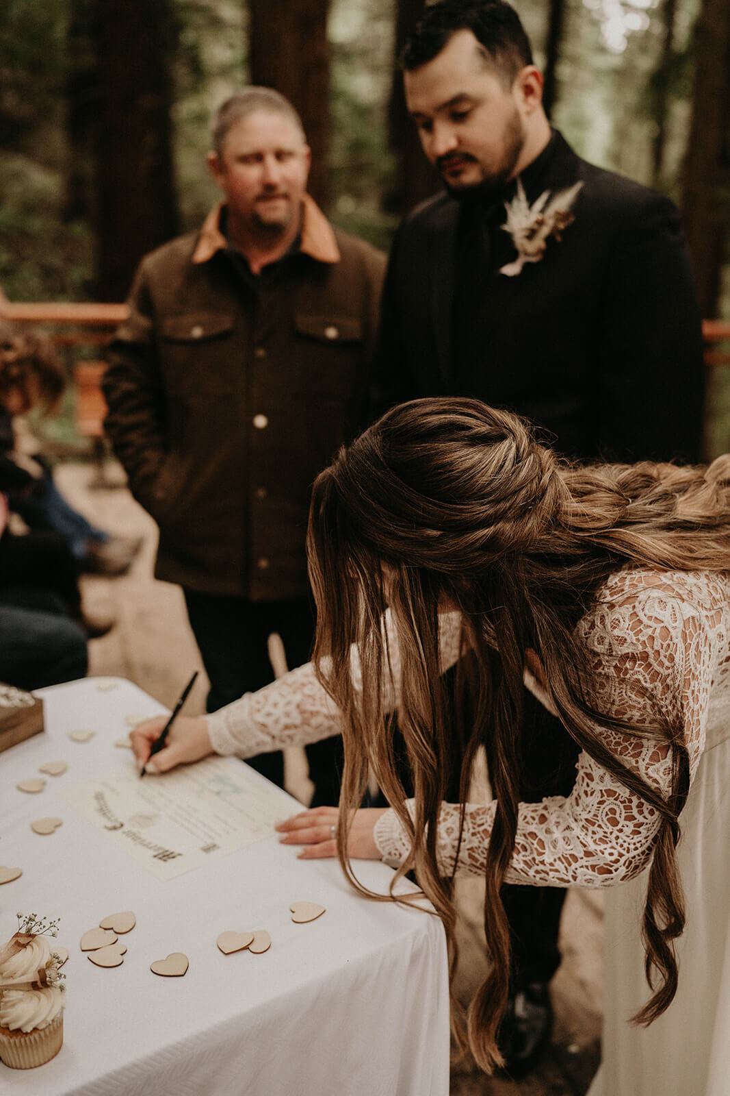 Bride signing marriage license at Oregon forest wedding