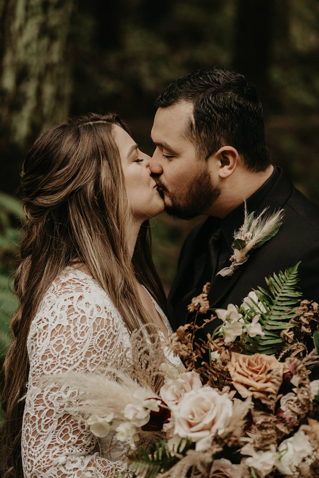 Bride and groom kiss during couple portraits at Hoyt Arboretum