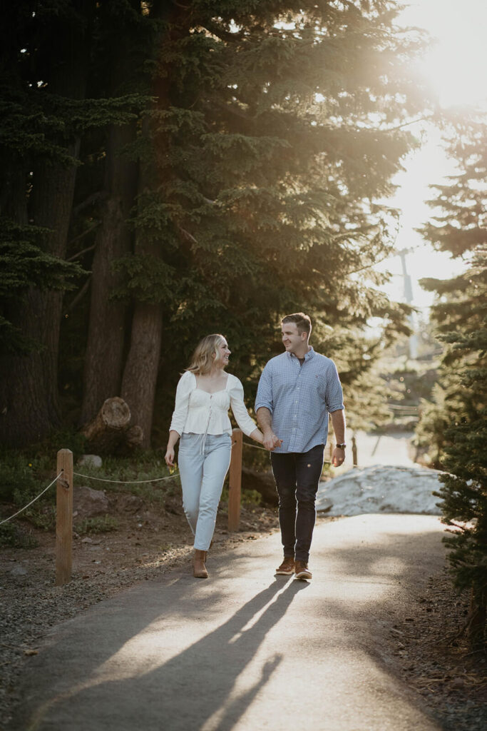 Couple holding hands walking down a path at Timberline Lodge