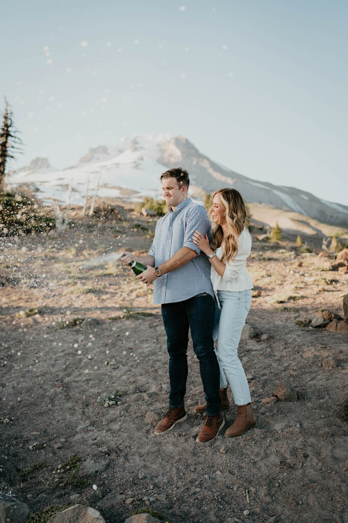 Couple popping champagne during Mt Hood engagement session