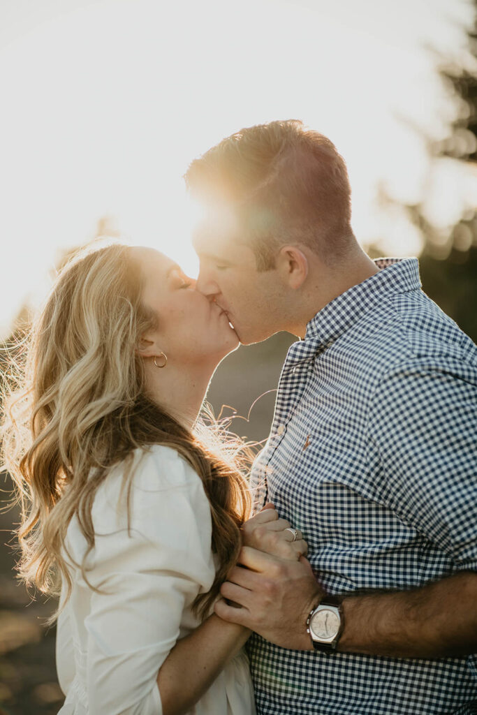 Couple kissing during sunset engagement photo session