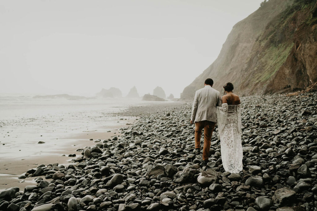 Bride and groom walking along the Oregon coast for their elopement