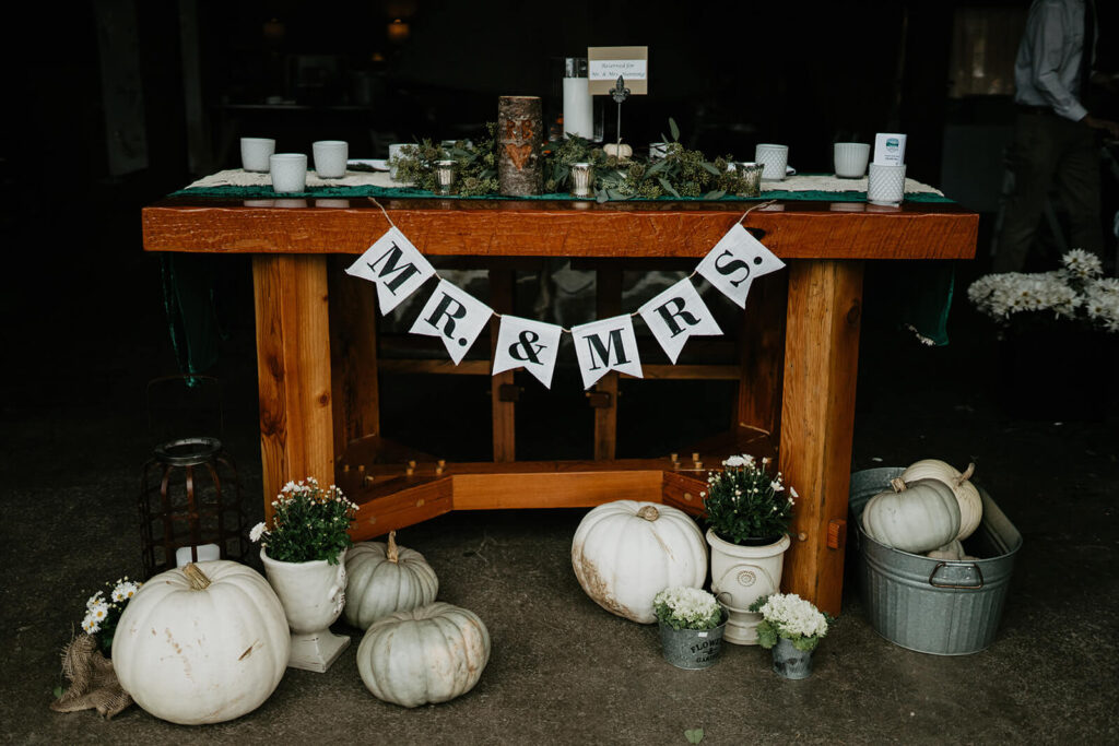 Wedding reception table with white banner that reads "Mr & Mrs"
