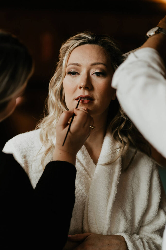 Bride getting makeup done for Oregon wedding