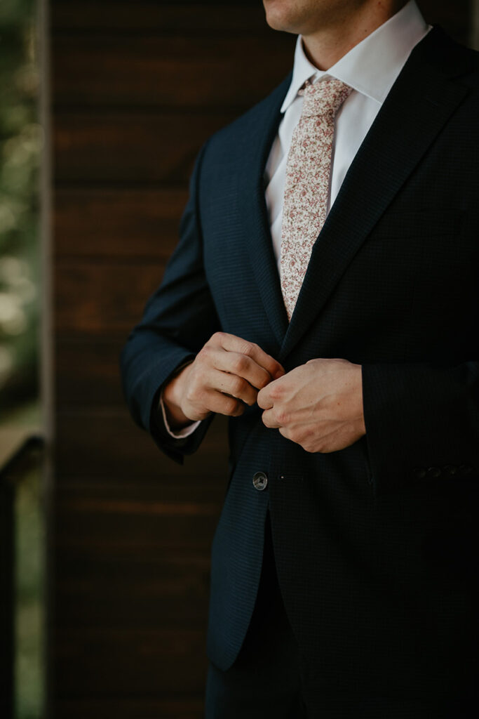 the groom buttoning up his suit. 