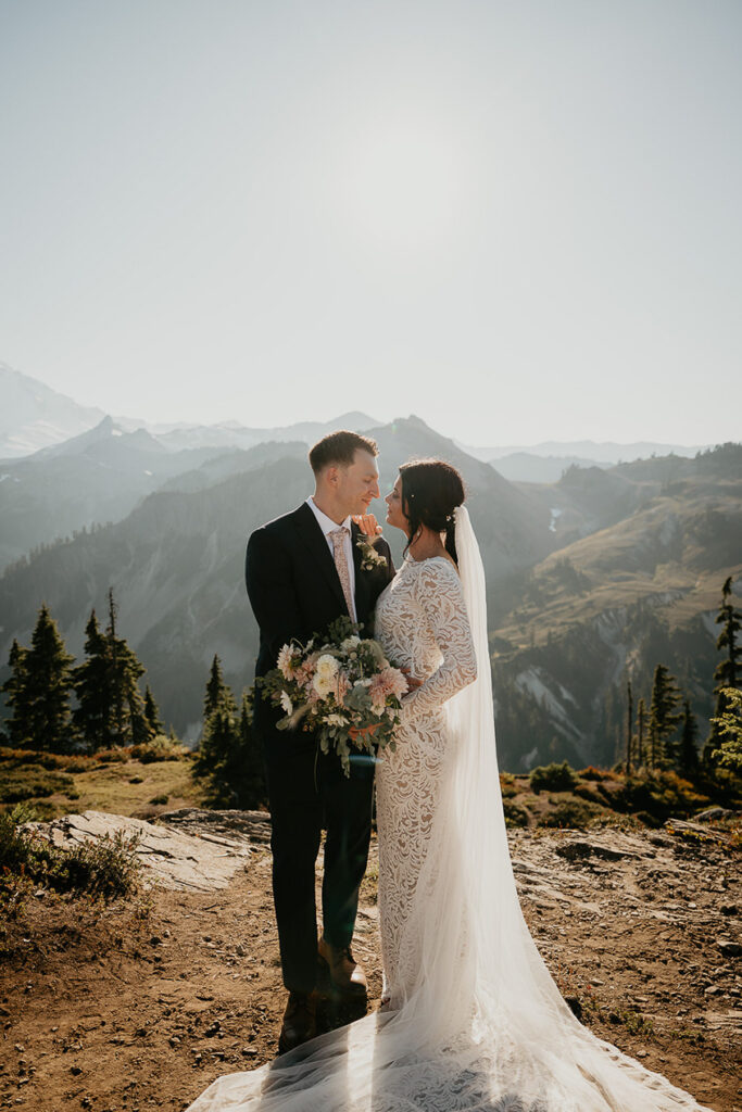 the newlyweds looking deeply into each other's eyes in the mountains. 