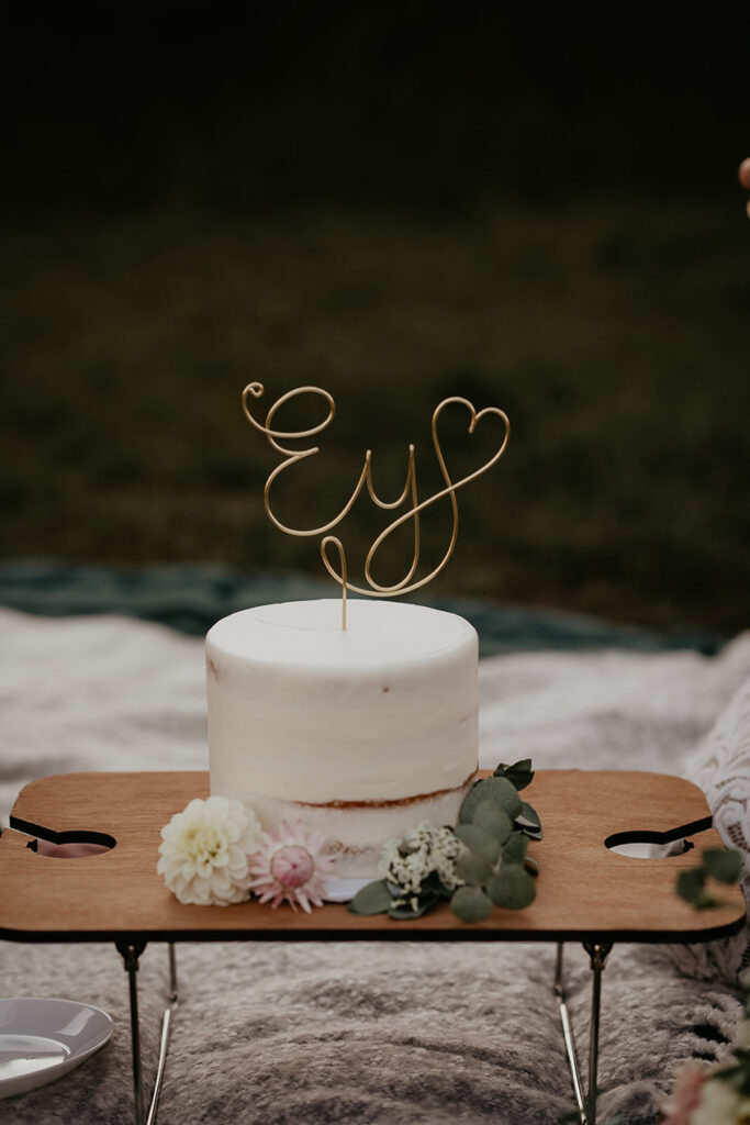 A wedding cake on a wooden platter. 