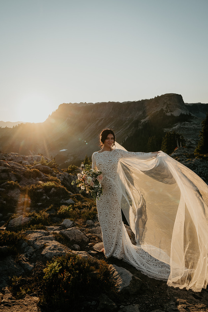 the bride showing off her veil at sunset. 