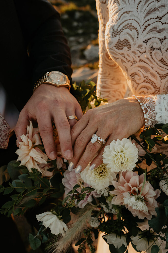 the newlywed's hands, showing off their wedding rings, and a bouquet of flowers. 