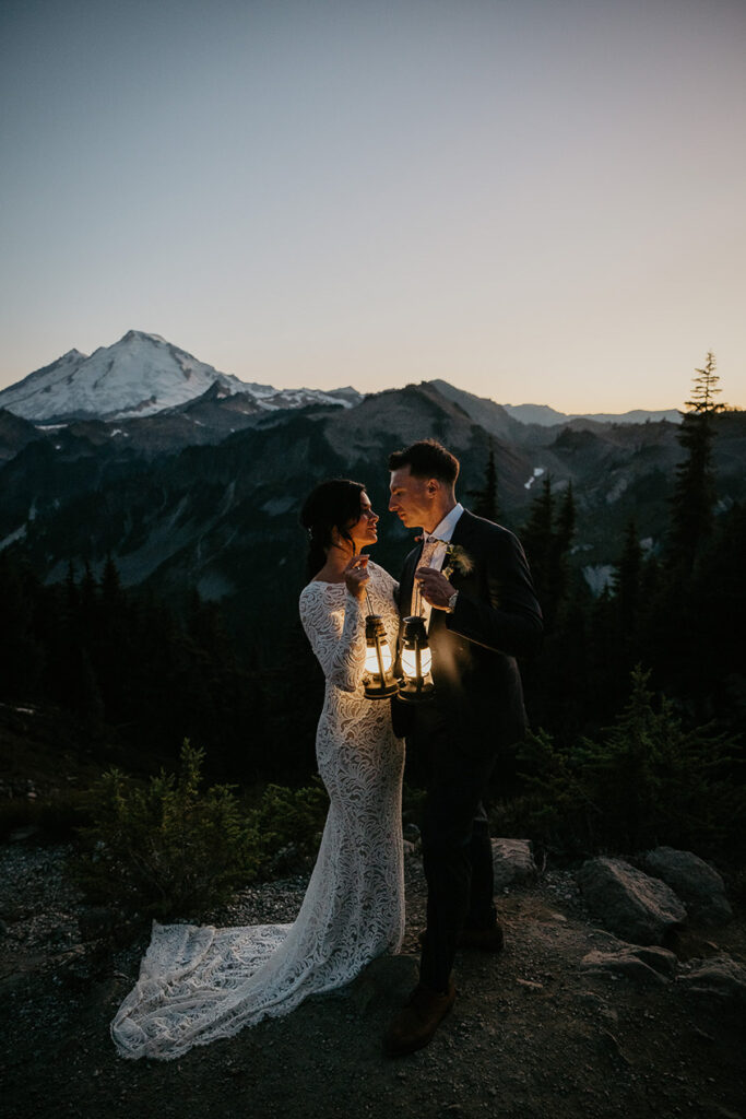 the newlyweds holding lanterns as the sun sets on their North Cascades elopement. 