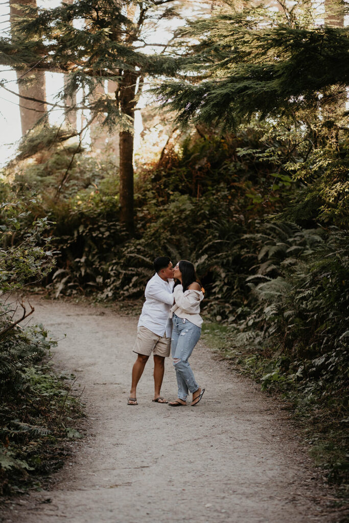 Two women kissing on a path during Oregon engagement session