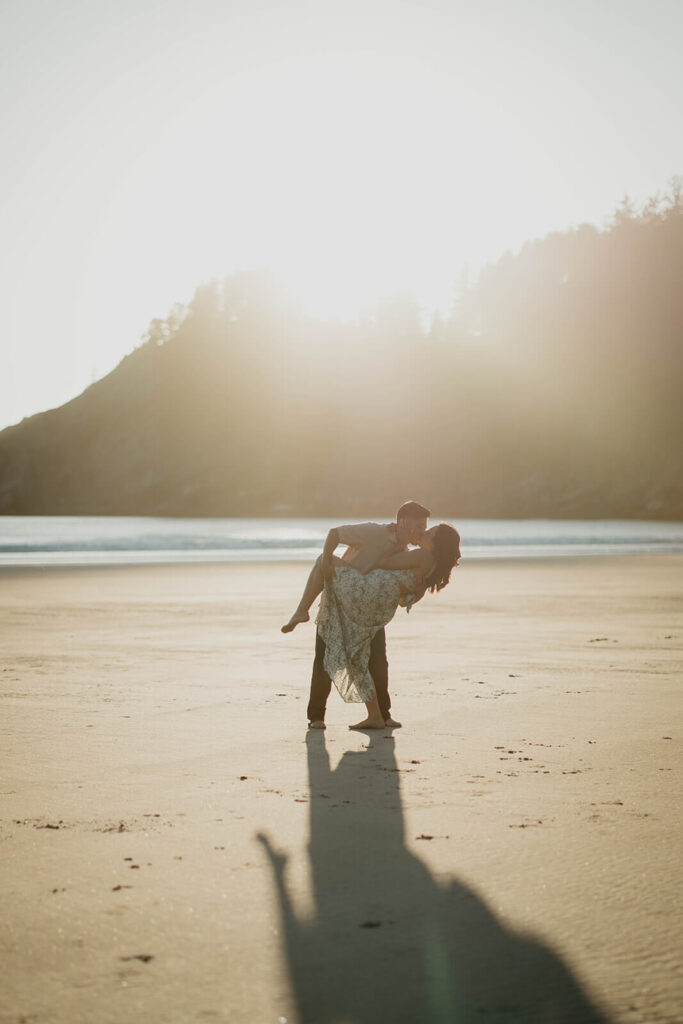 Two women kissing on the beach for Oregon engagement photos