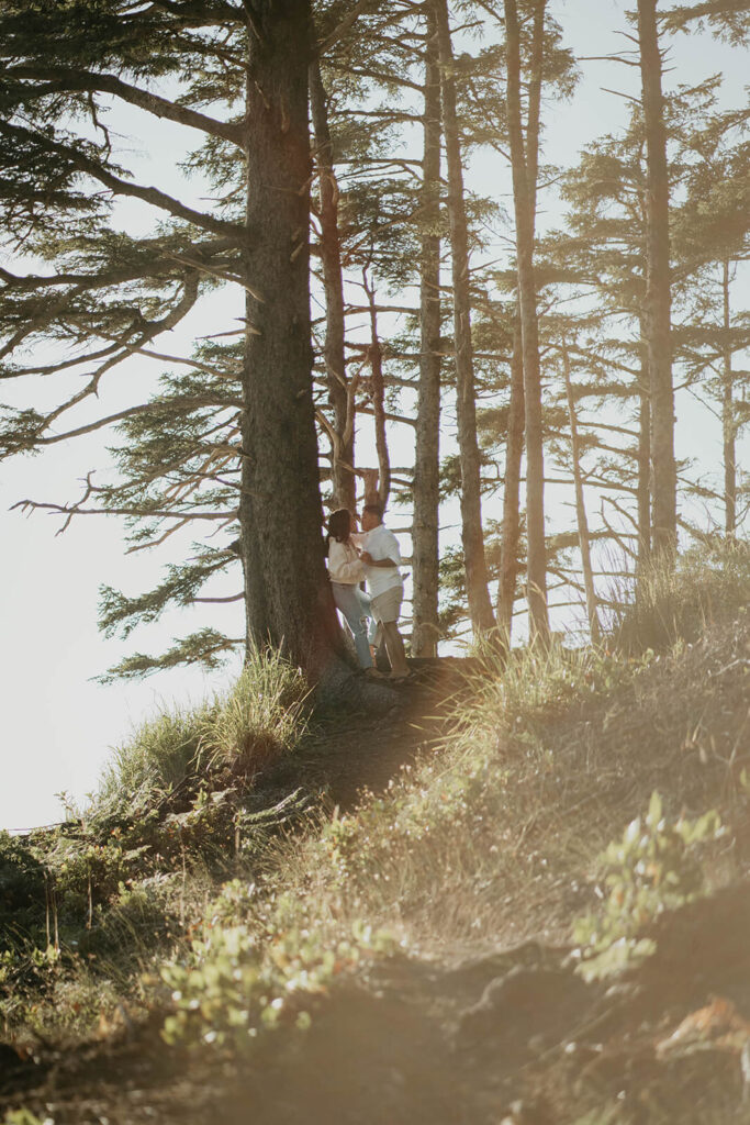 Two women leaning against a tree, kissing during Oregon engagement session