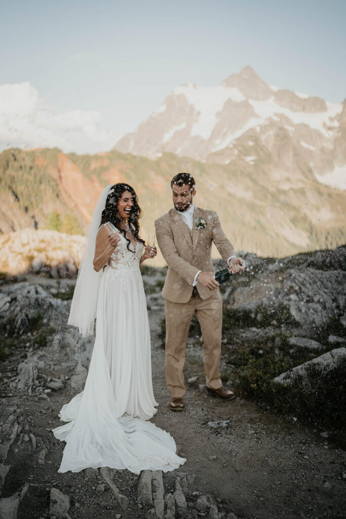 Bride and groom pop a bottle of champagne at Artist Point after North Cascades elopement