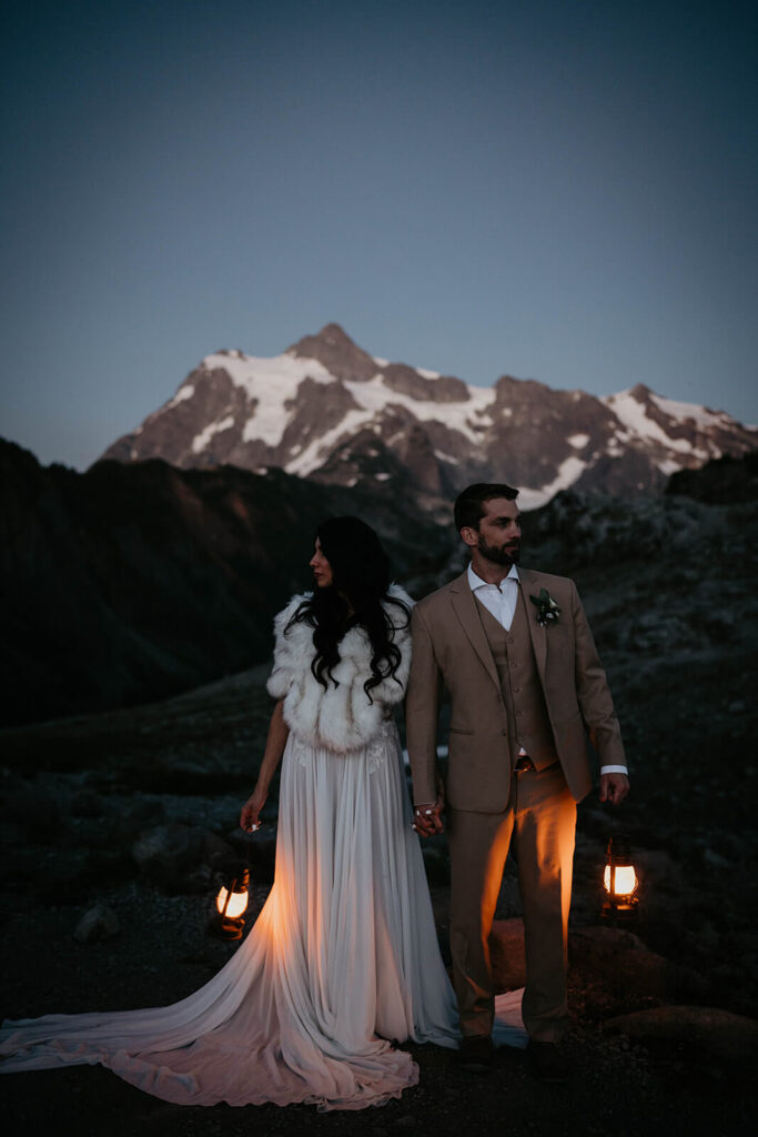 Bride and groom holding lanterns during blue hour photos in the North Cascades