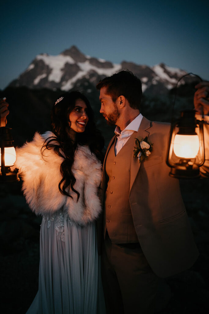Bride and groom holding lanterns during blue hour in the North Cascades
