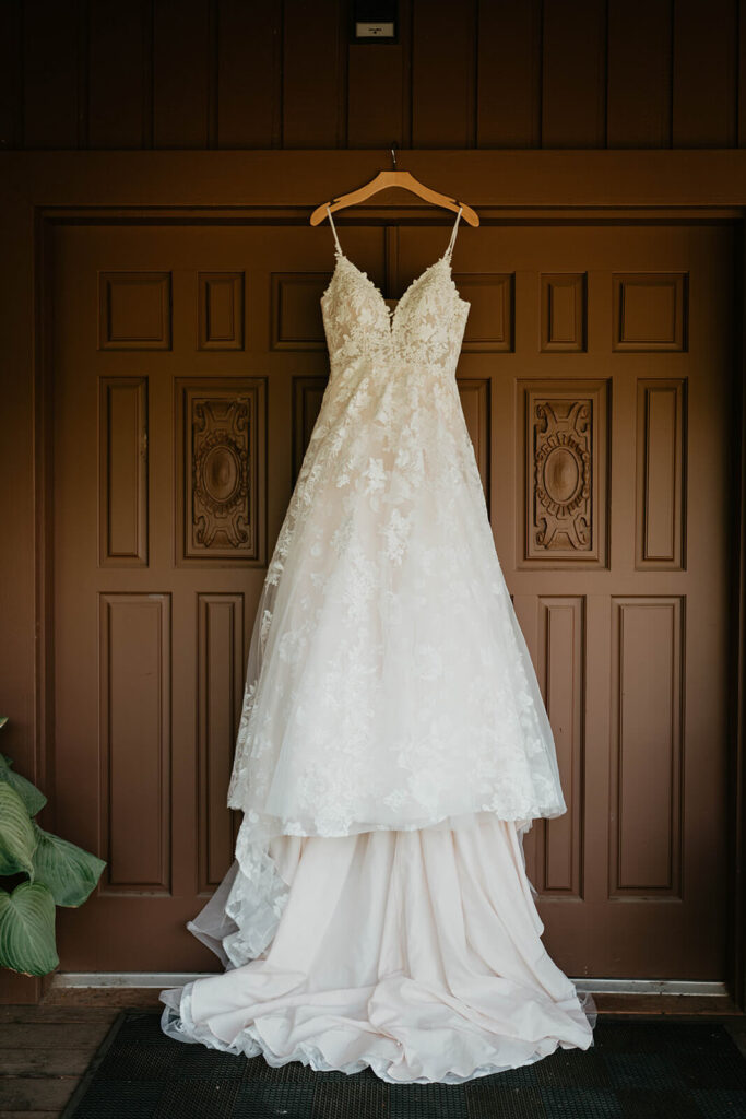 White wedding dress hanging from wood door at Furioso Vineyards