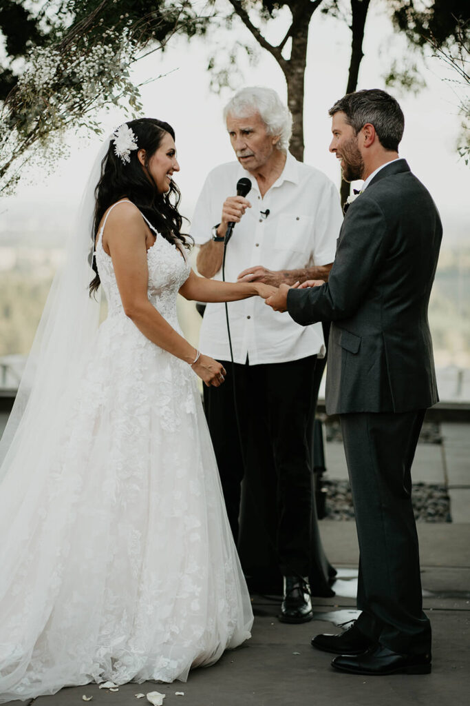 Bride and groom exchange rings at outdoor vineyard wedding