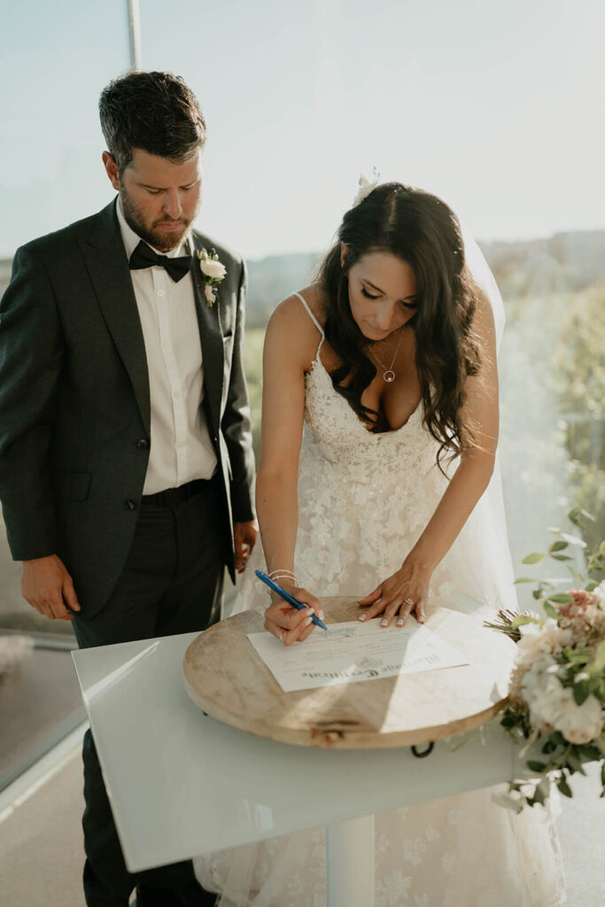 Bride and groom signing marriage license at Oregon vineyard wedding
