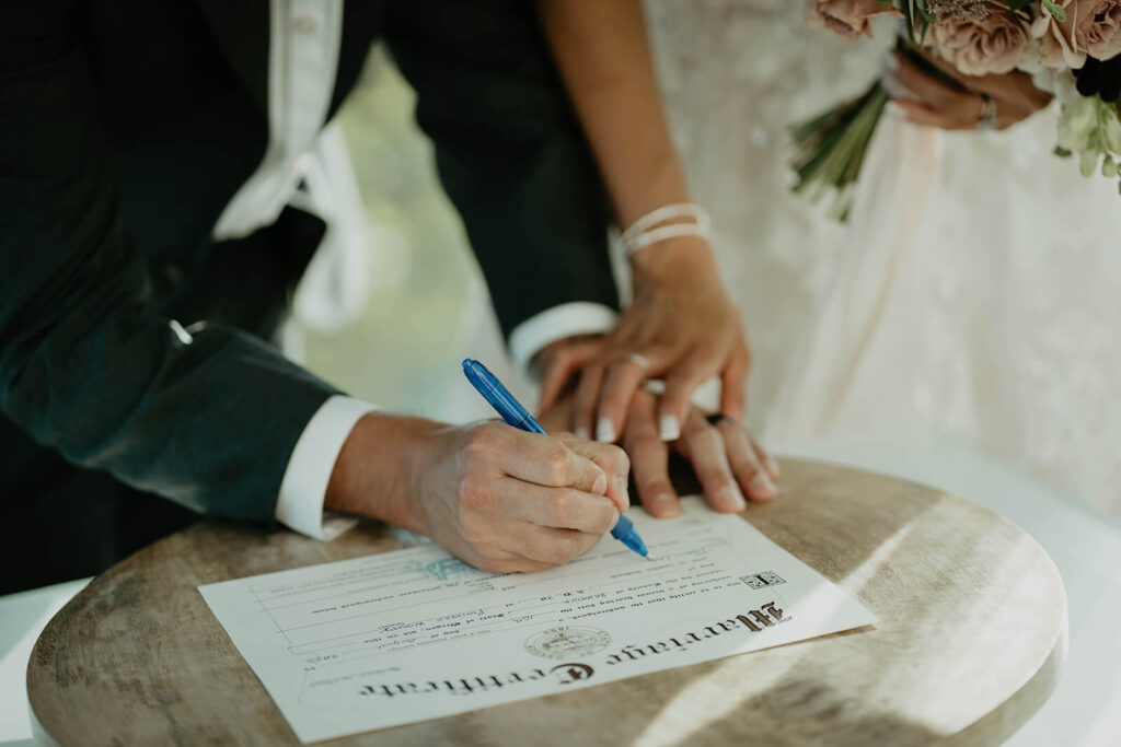 Bride and groom signing Oregon mariage license