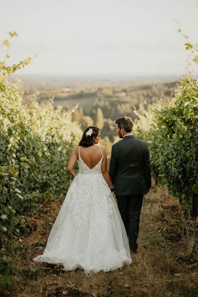 Bride and groom walking through vineyards at Furioso Vineyards