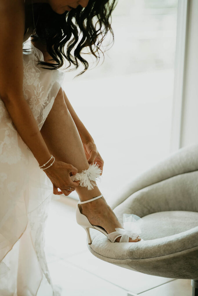 Bride adjusting white garter at Oregon vineyard wedding
