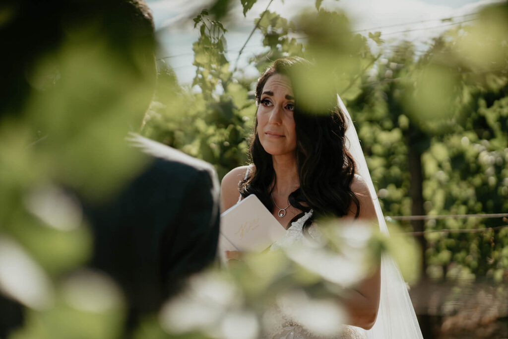 Bride and groom exchange private vows in the vineyard at Oregon intimate wedding