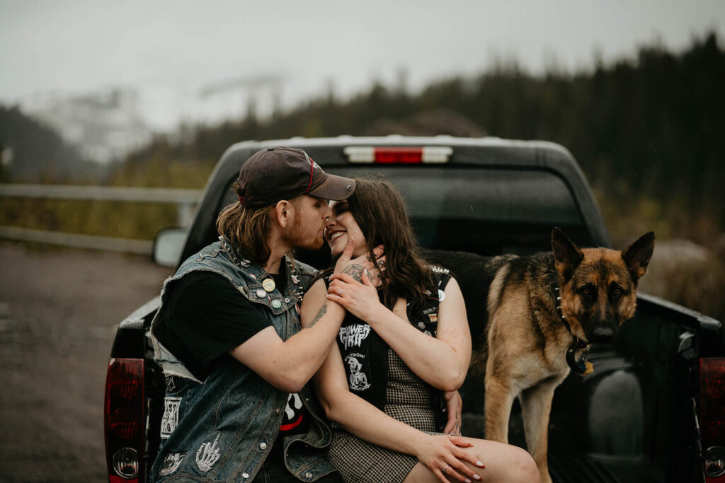 Couple sitting and kissing on the back of a truck