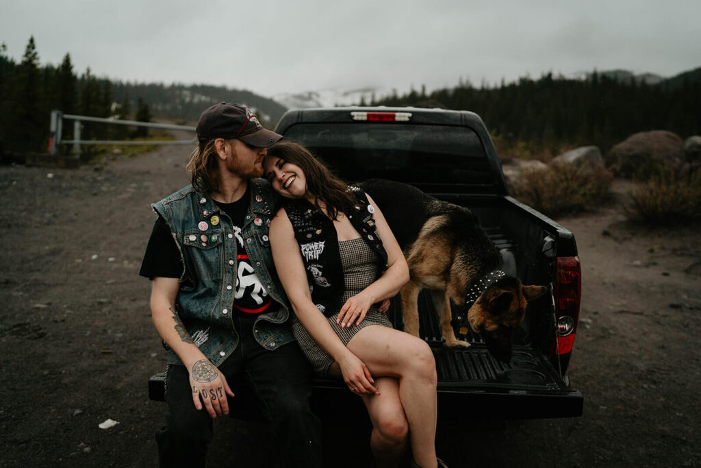 Couple sitting on the back of a truck with their dog during Mt Hood engagement session