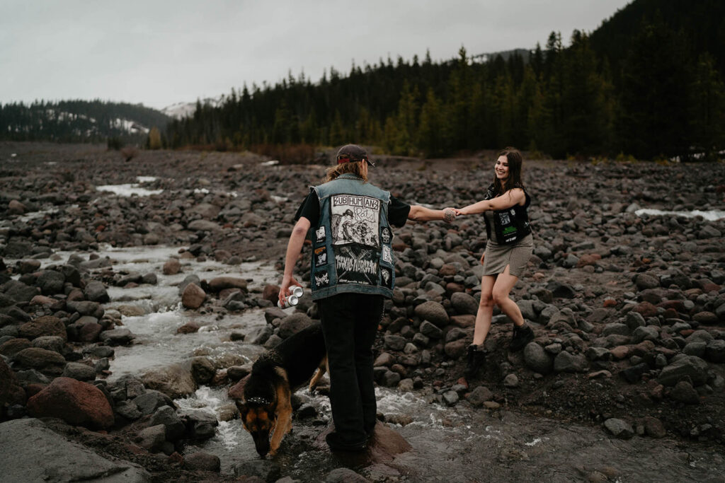 Couple walking across a stream at Mt Hood for their engagement photos