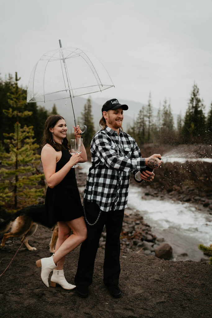 Couple popping champagne for engagement photo session