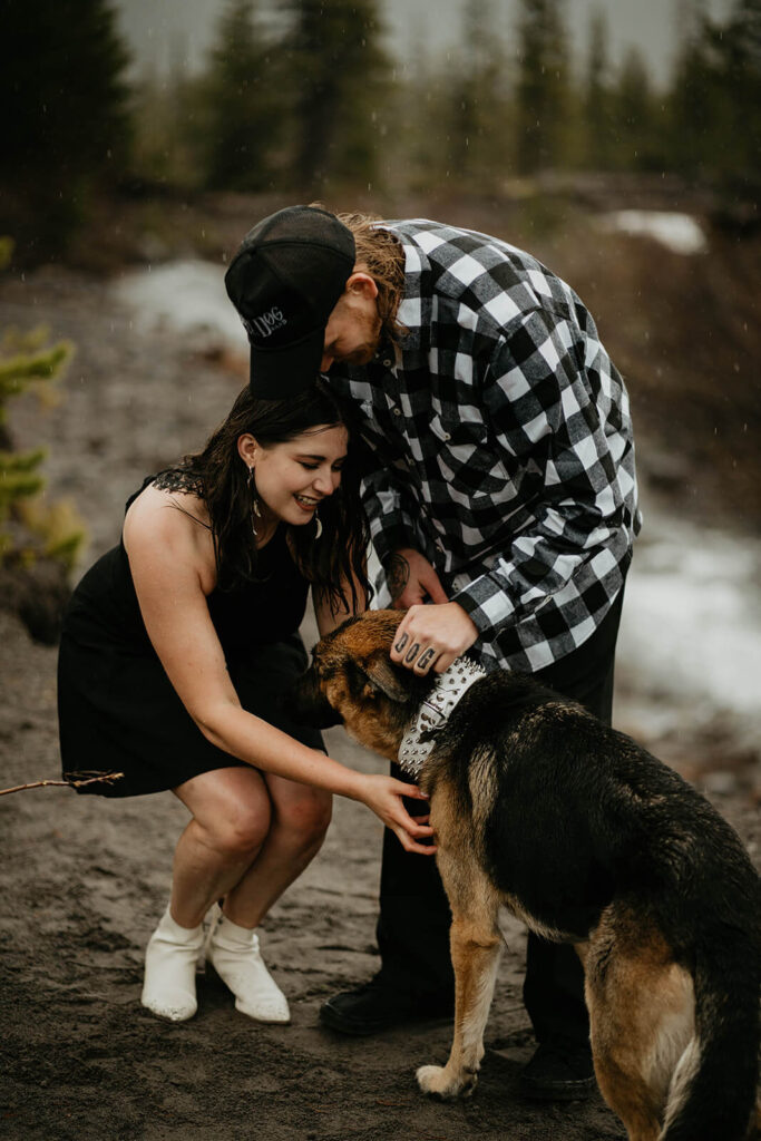 Couple petting their german shepherd dog during unique engagement photo session at Mt Hood