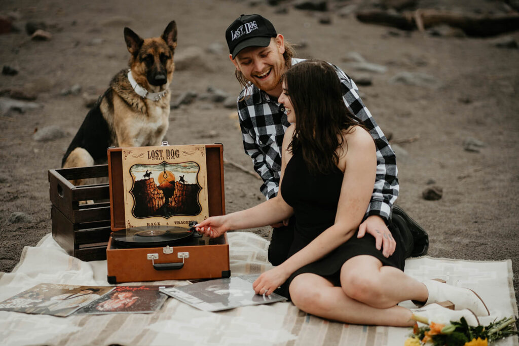 Couple adjusting records on portable record player during Mt Hood engagement session
