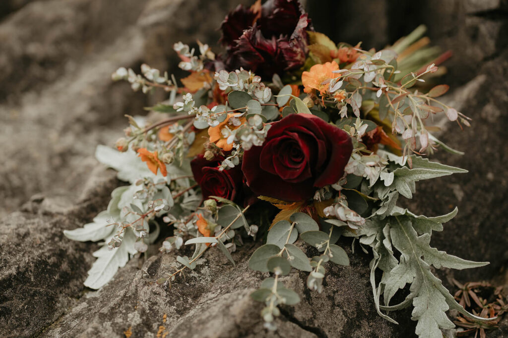 Deep red, orange and green floral bouquet for elopement ceremony