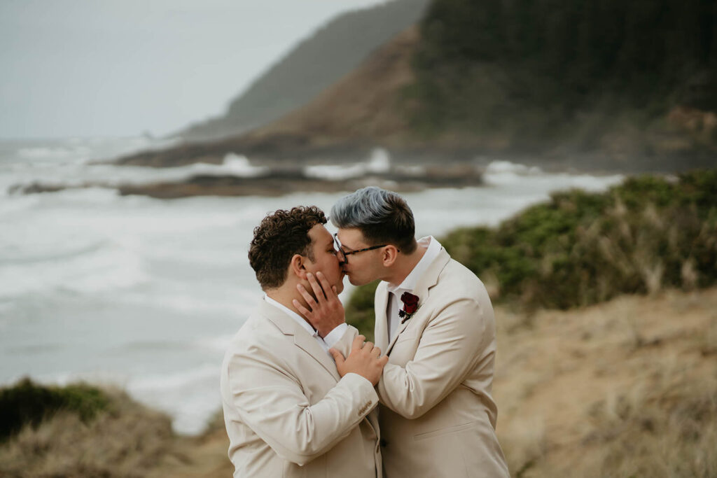Grooms kiss after elopement ceremony on the Oregon Coast