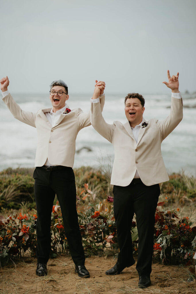Grooms cheer after their Oregon Coast elopement ceremony