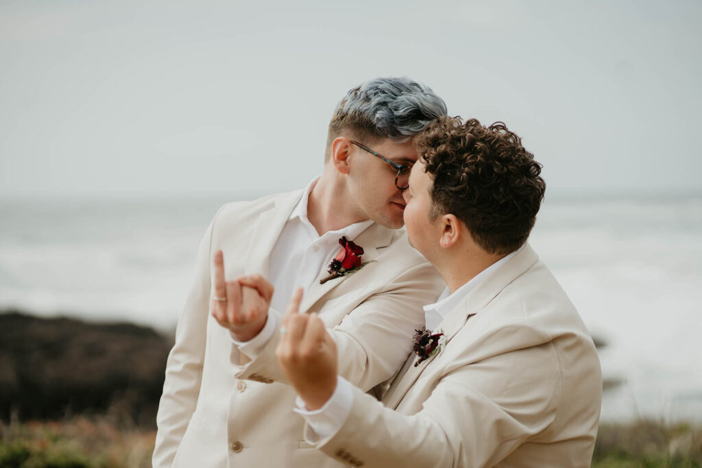 Grooms kiss at their elopement on the rocky coast in Oregon