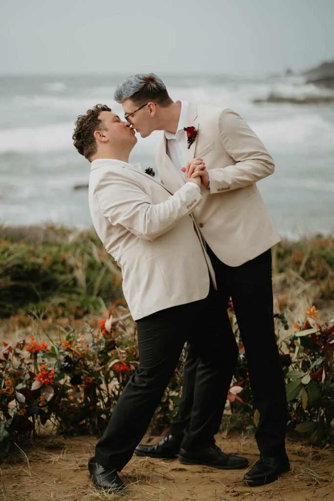 Grooms kiss at their elopement on the rocky coast in Oregon