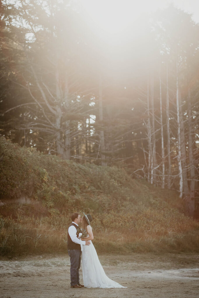 Bride and groom kiss on the beach for Oregon Coast elopement