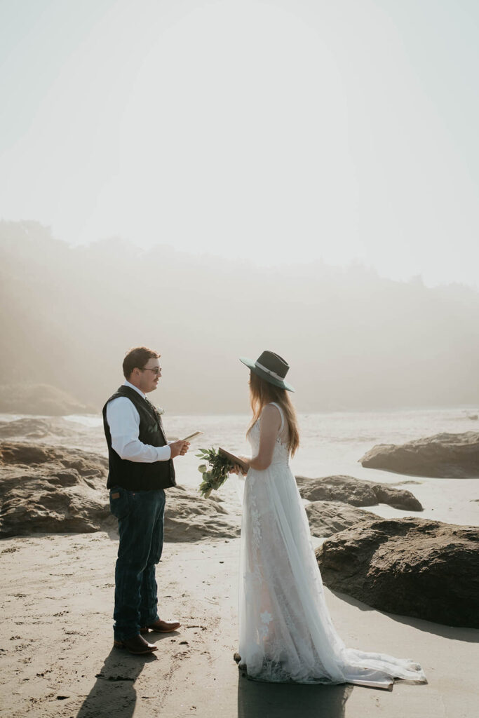 Bride and groom exchange vows during intimate beach wedding ceremony