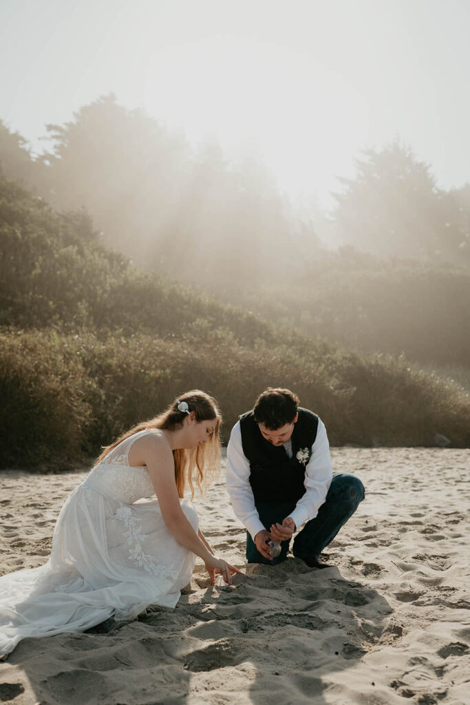 Bride and groom collect sand from their intimate beach wedding on the Oregon Coast