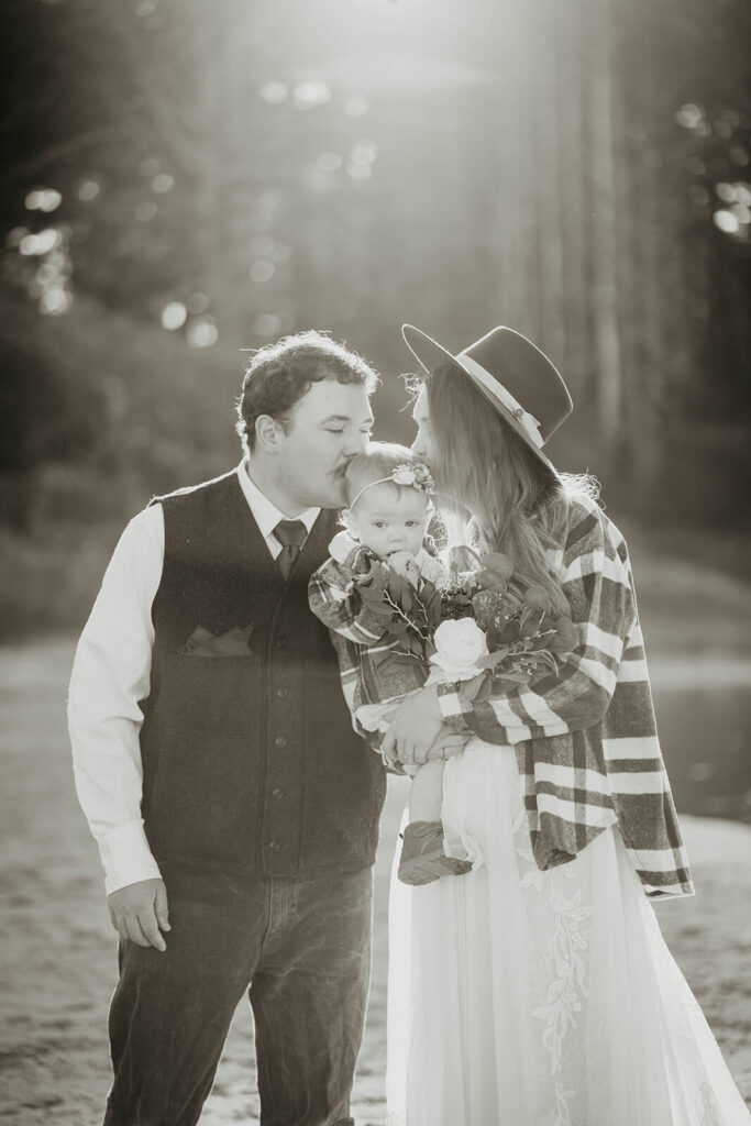 Bride and groom kiss daughter on the head before Oregon Coast elopement