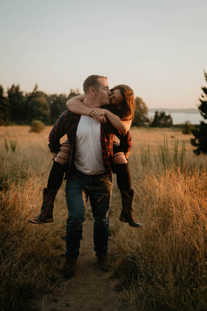 Woman riding on man's back during Seattle engagement photos at Discovery Park