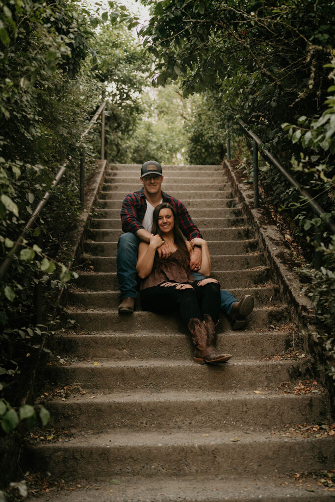 Couple sitting on the steps at Discovery Park during their Seattle engagement photos