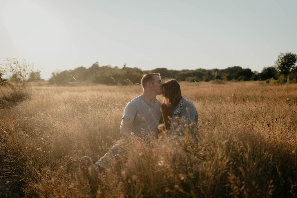 Couple sitting in the grass during their engagement photo session at Discovery Park Seattle