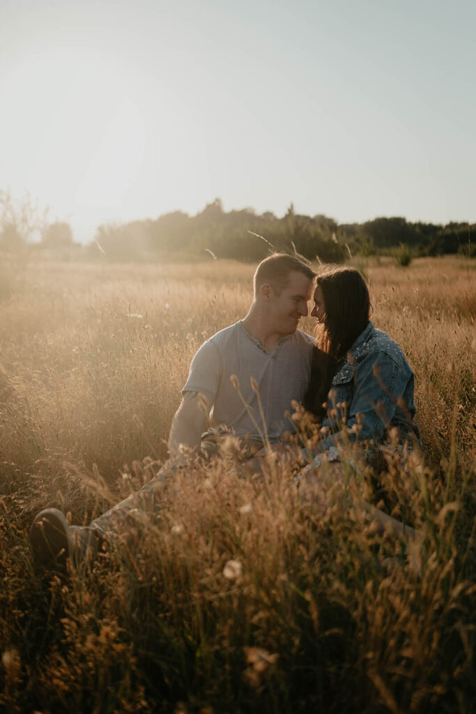 Couple sitting in the grass during their engagement photo session at Discovery Park Seattle