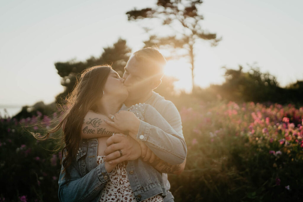 Couple kissing during sunset portraits  in Discovery Park
