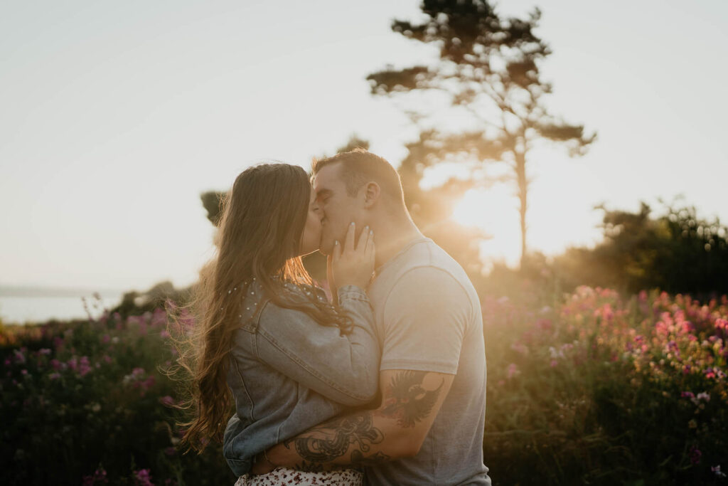 Couple kissing during sunset portraits  in Discovery Park