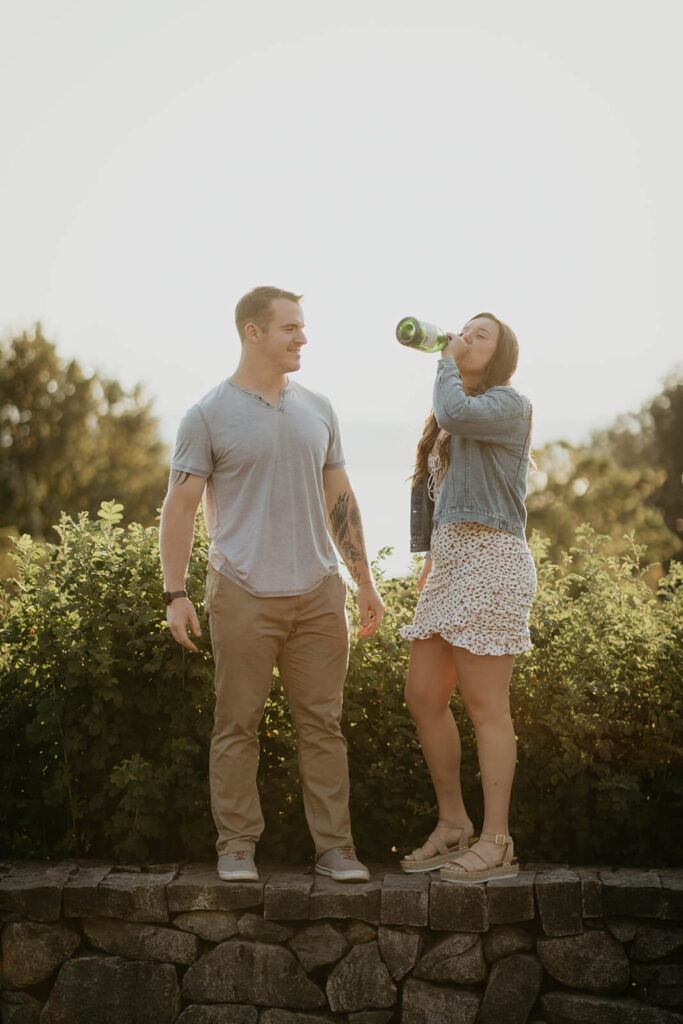 Woman drinking from champagne bottle at Seattle engagement photo session